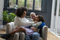 Smiling women playing with daughter at home