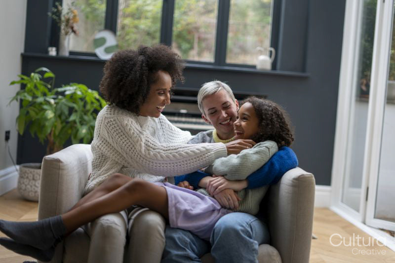 Smiling women playing with daughter at home