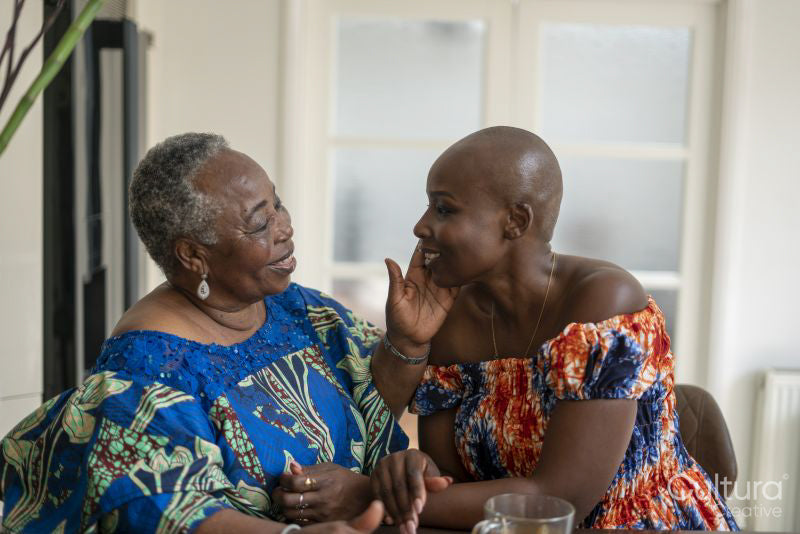 Smiling senior woman touching adult daughters face at home