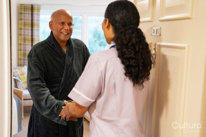 Nurse visiting senior man in his room at nursing home