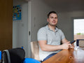 Man sitting at table with smart phone and home coronavirus test