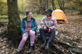 Smiling female friends camping in forest