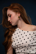 Studio portrait of a woman in a polka dot top with windswept hair