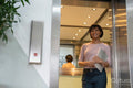 Businesswoman walking out of elevator in office