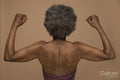 Rear view of shirtless senior woman flexing muscles
