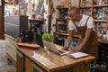 Cafe owner using laptop at counter