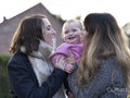 Female couple holding baby
