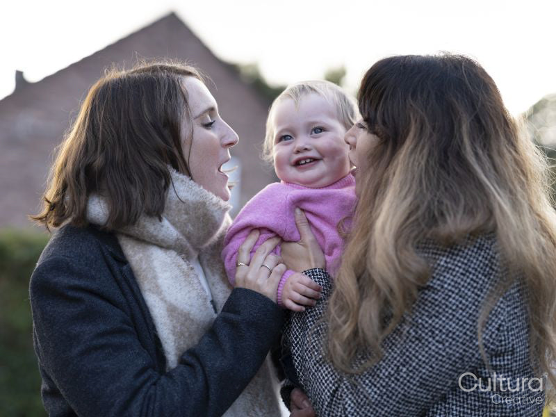 Female couple holding baby