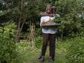 Smiling mature couple holding vegetables from garden