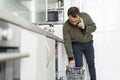 Mature man unloading dishwasher and talking on phone