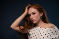 Studio portrait of a woman in a polka dot top with windswept hair