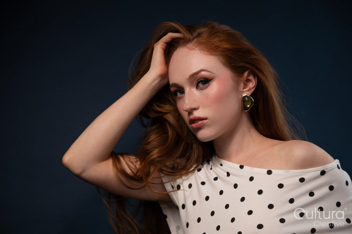 Studio portrait of a woman in a polka dot top with windswept hair