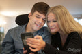 Mother using smartphone with disabled son