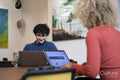 Man and woman working on laptops in office