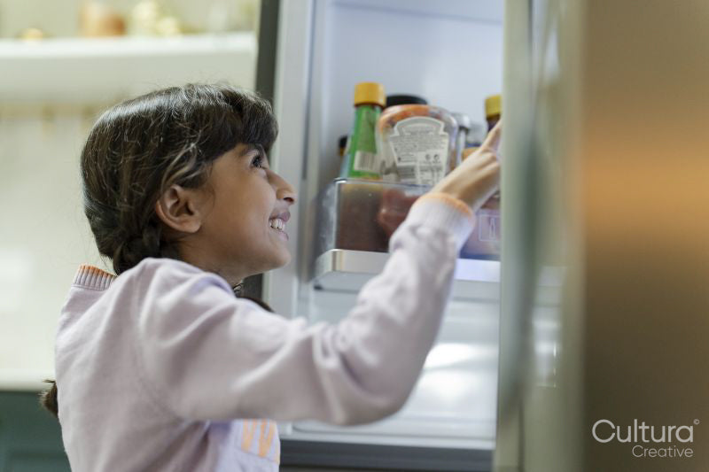 Little girl opening fridge