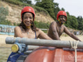 Portrait of friends standing with raft in lake