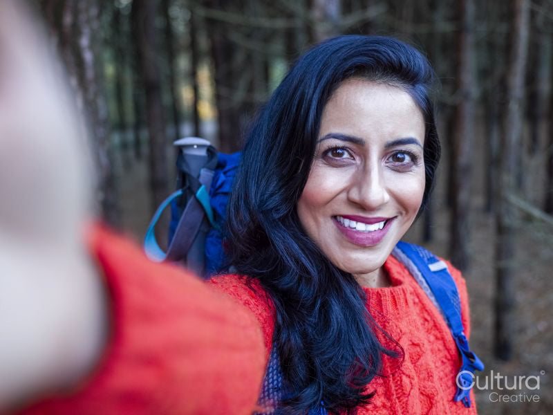 Portrait of smiling female hiker in forest