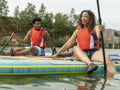 Friends having fun while paddleboarding on lake