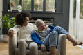 Smiling couple relaxing on armchair at home