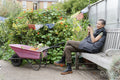 Smiling woman with smart phone in vegetable garden