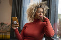 Woman using smart phone and looking through window