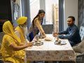 Family in traditional clothing eating meal at home
