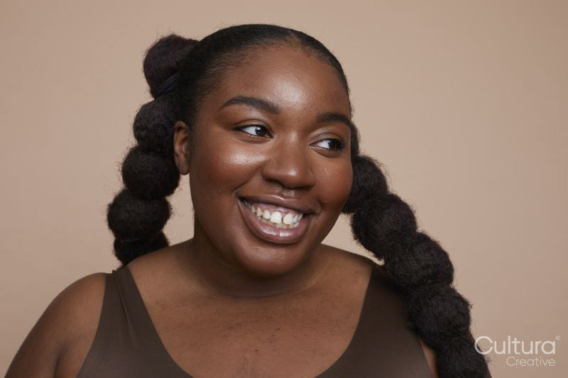 Studio shot of smiling young woman with braided hair
