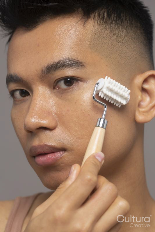 Studio portrait of person using face roller