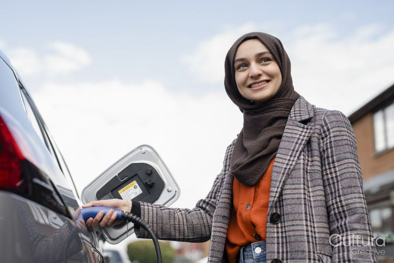 Woman wearing hijab charging electric car