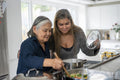 Two women preparing meal in kitchen