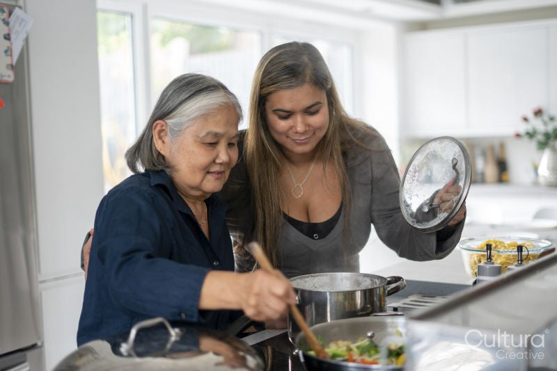 Two women preparing meal in kitchen