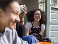 Mother with two daughters relaxing in backyard