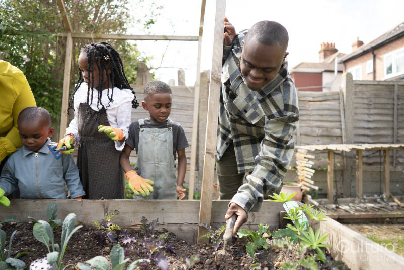 Family with children planting seedlings in garden