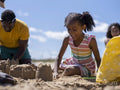 Family with daughter building sand castles on beach