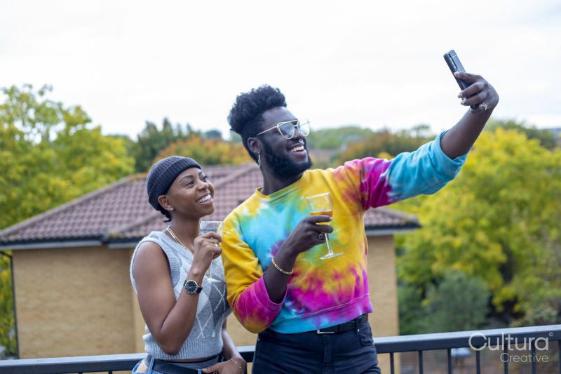 Friends smiling at taking selfie on rooftop terrace