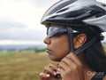 Woman putting on bicycle helmet
