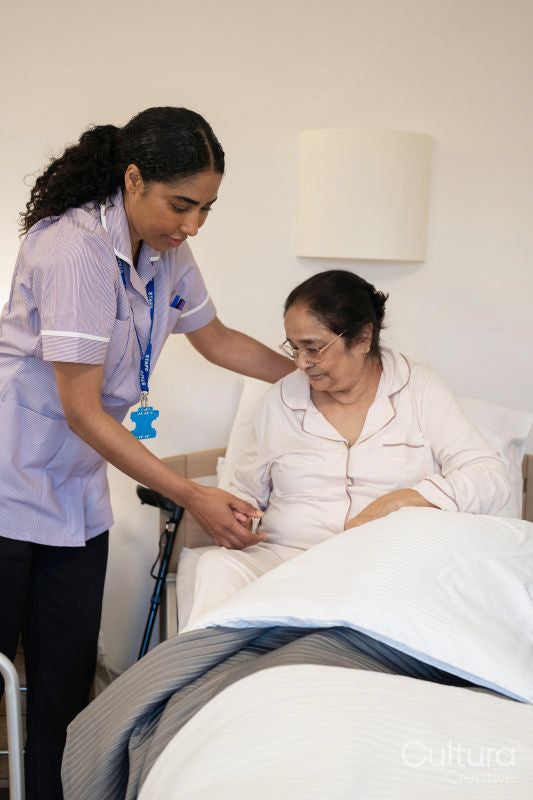 Nurse visiting senior lady in her room at nursing home