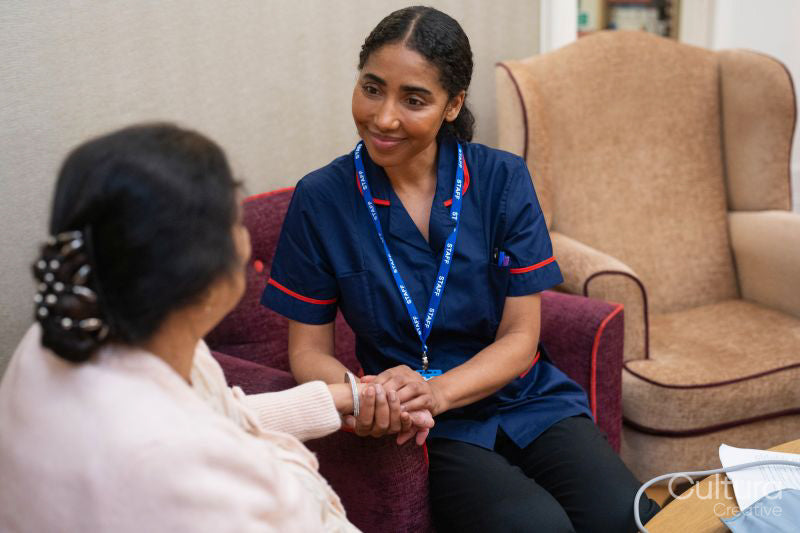 Nursing assistant taking care of senior woman in nursing home