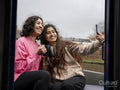 Two smiling women sitting on boat and taking selfie
