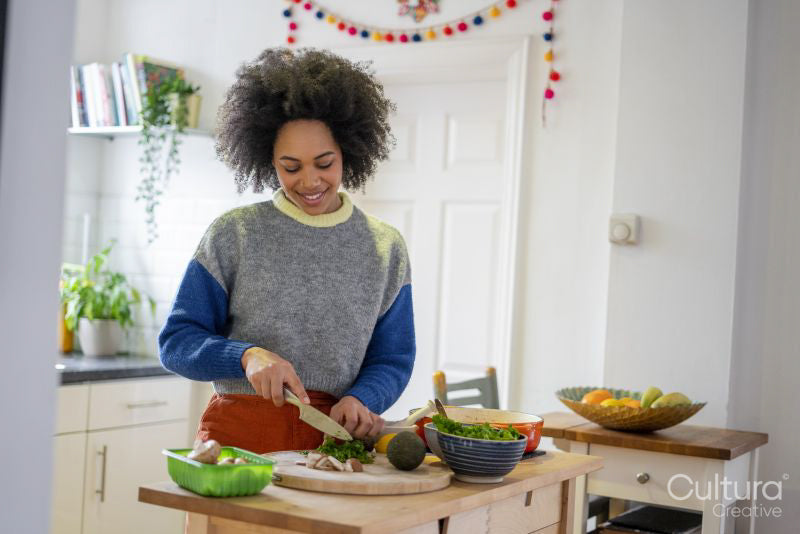 Smiling young woman cooking at home