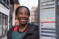 Portrait of happy young woman waiting on bus stop
