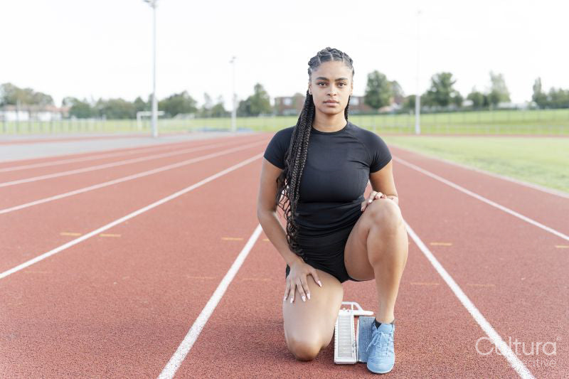 Female athlete preparing to run at stadium