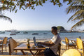 Man using laptop at beach cafe