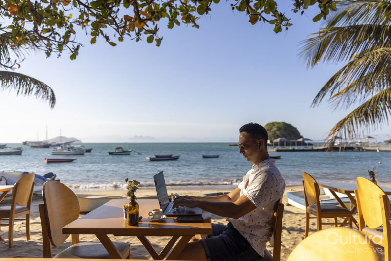 Man using laptop at beach cafe
