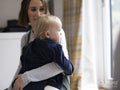Mother holding daughter wearing hearing aid