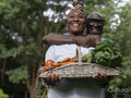 Smiling mature couple holding vegetables from garden