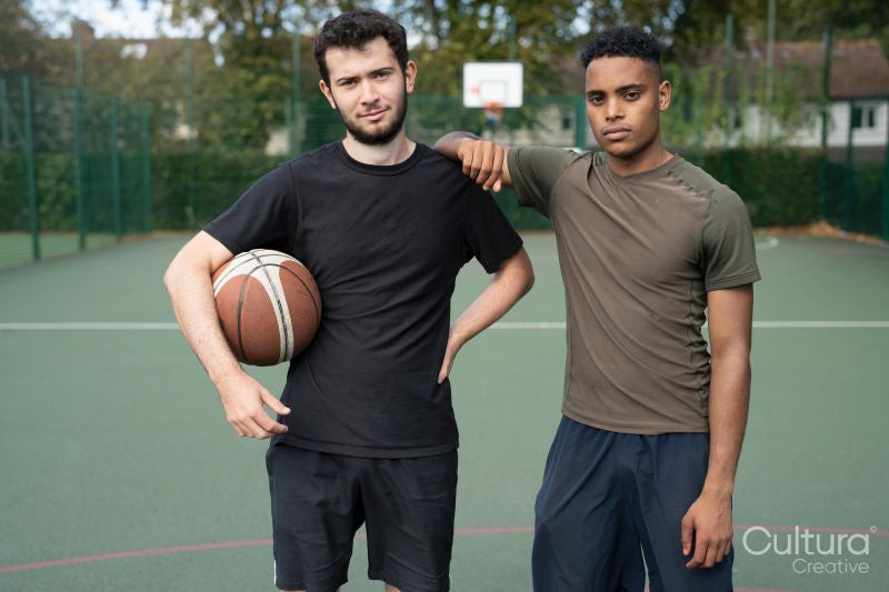 Portrait of two men standing in basketball court