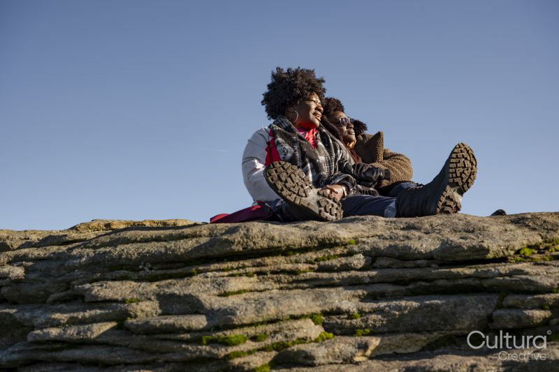 Two women relaxing on top of rock