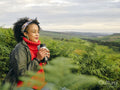 Woman holding insulated drink container and looking at landscape