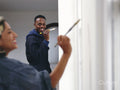 Smiling couple painting house walls